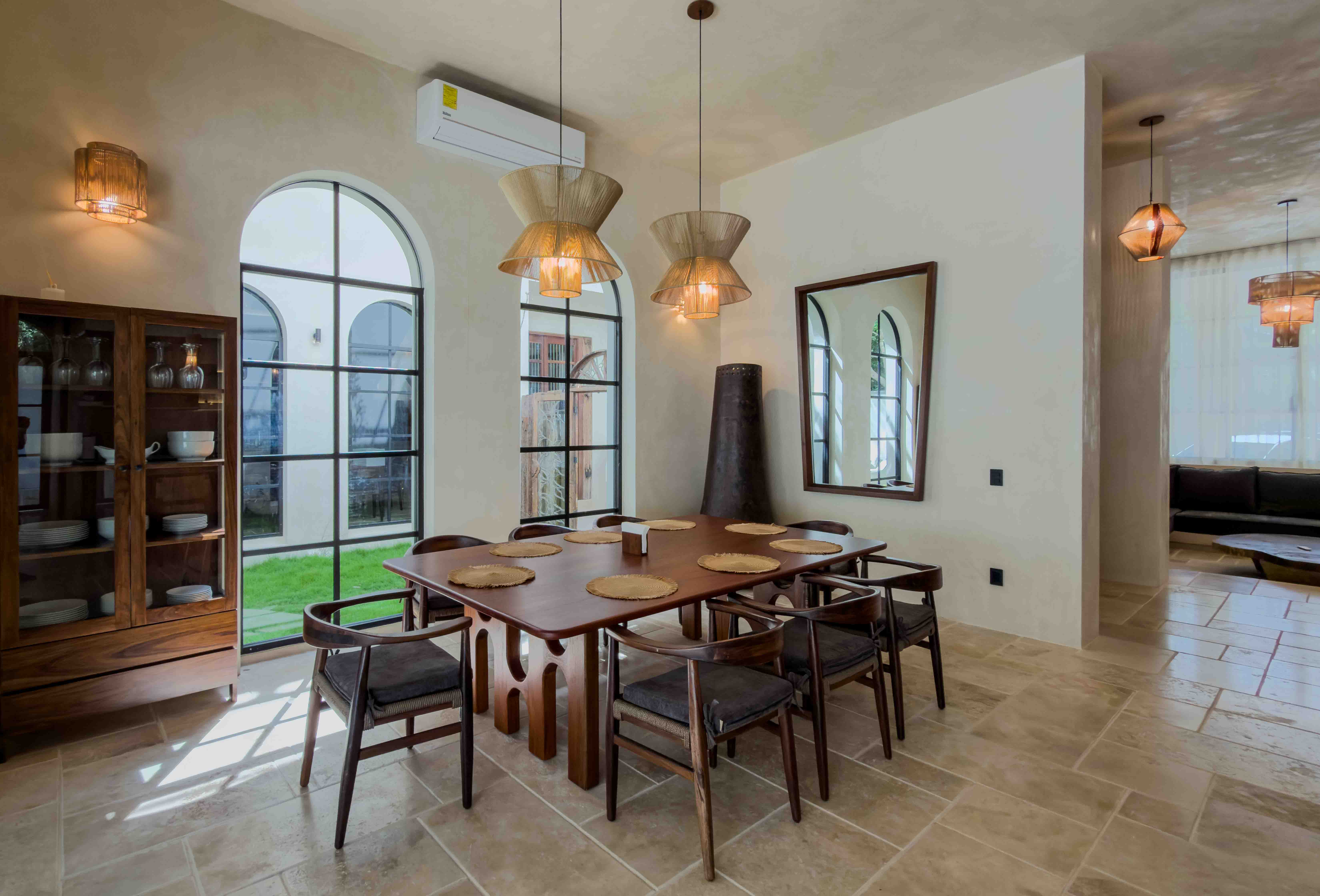 Elegant indoor dining area with arched windows and pendant lighting