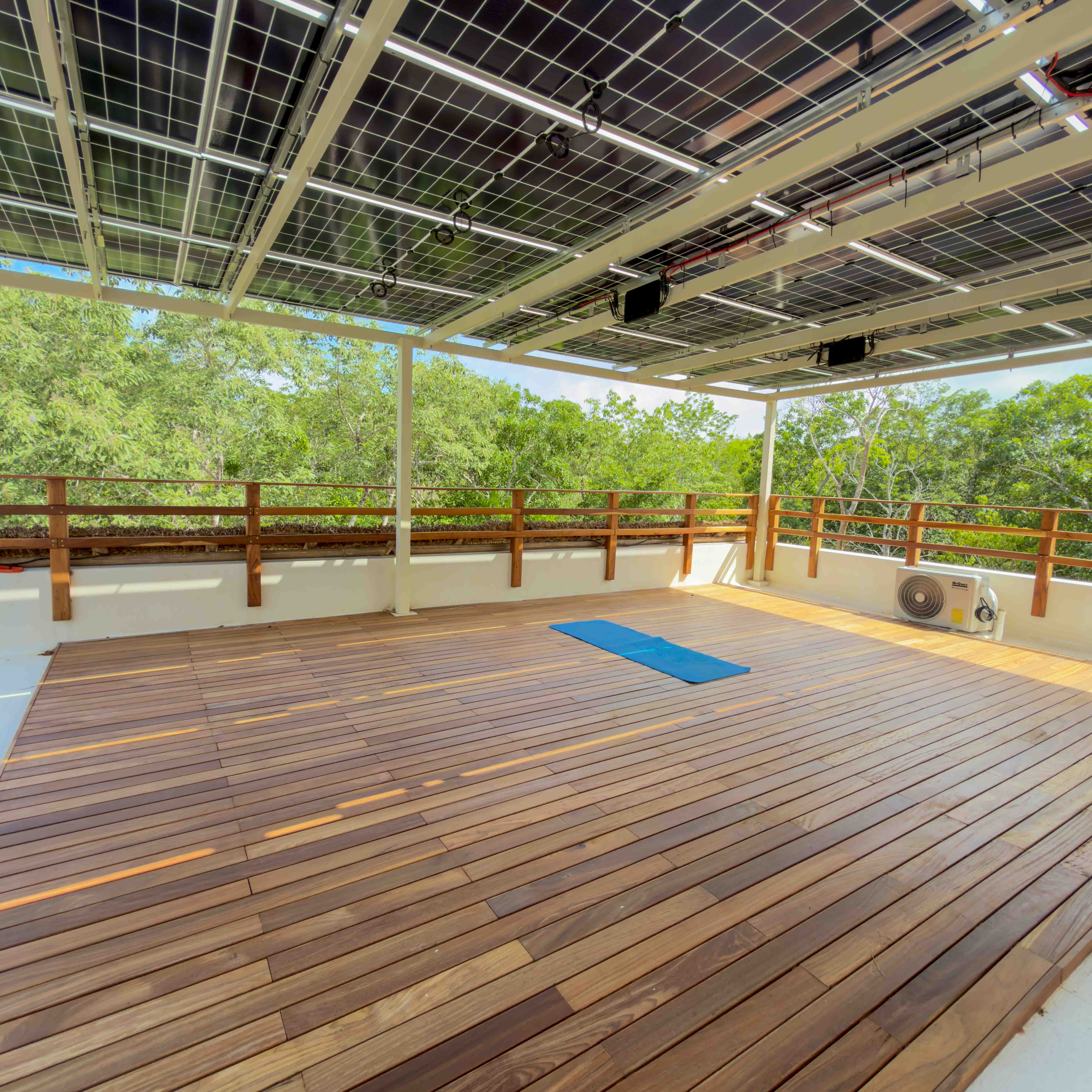 Rooftop yoga deck with solar panel canopy and jungle views