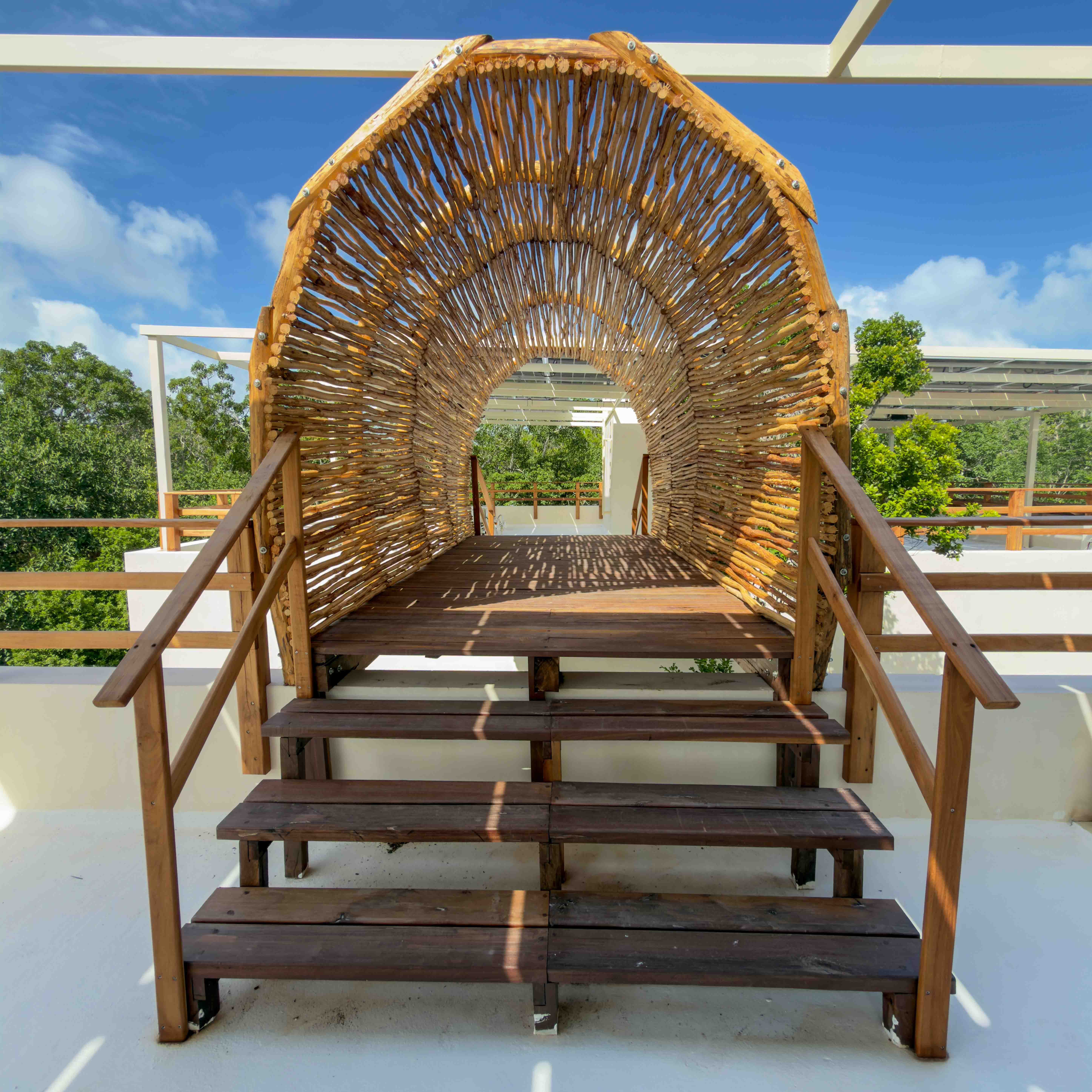 Architectural stick tunnel bridge on the rooftop with jungle views.