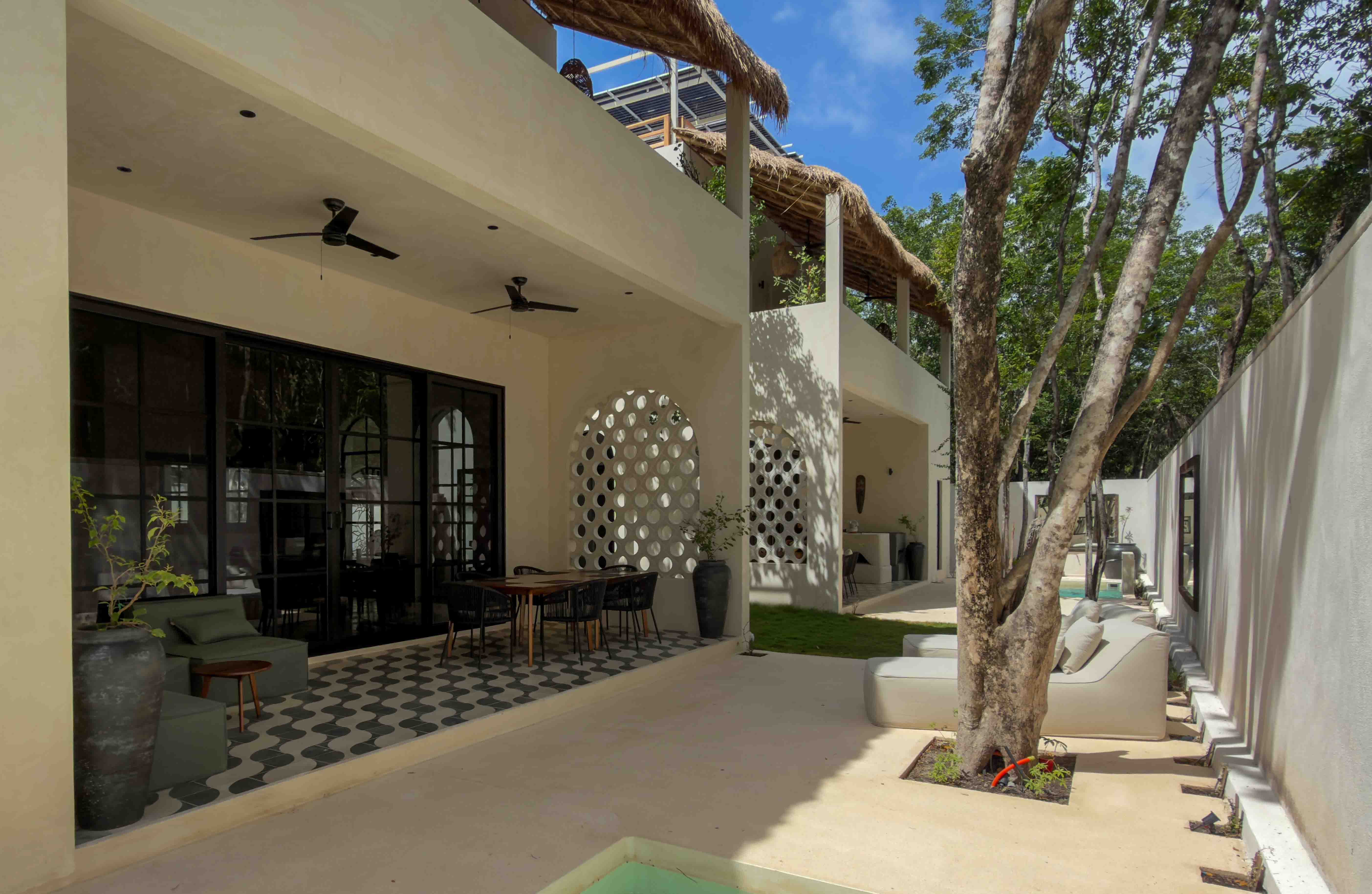 Covered patio with dining area and lounge seating overlooking the garden