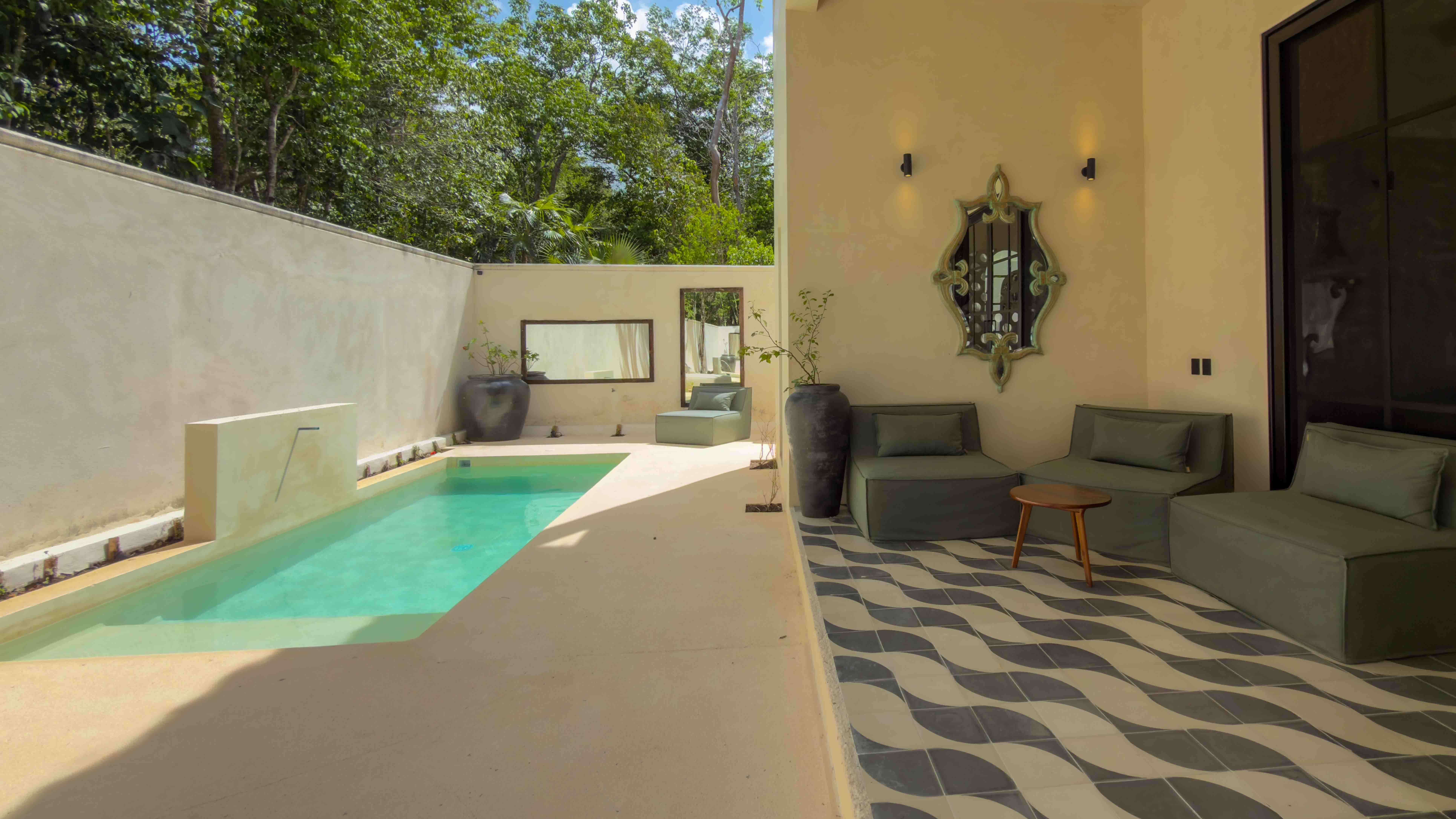Outdoor lap pool with adjacent lounge area and patterned tile terrace.