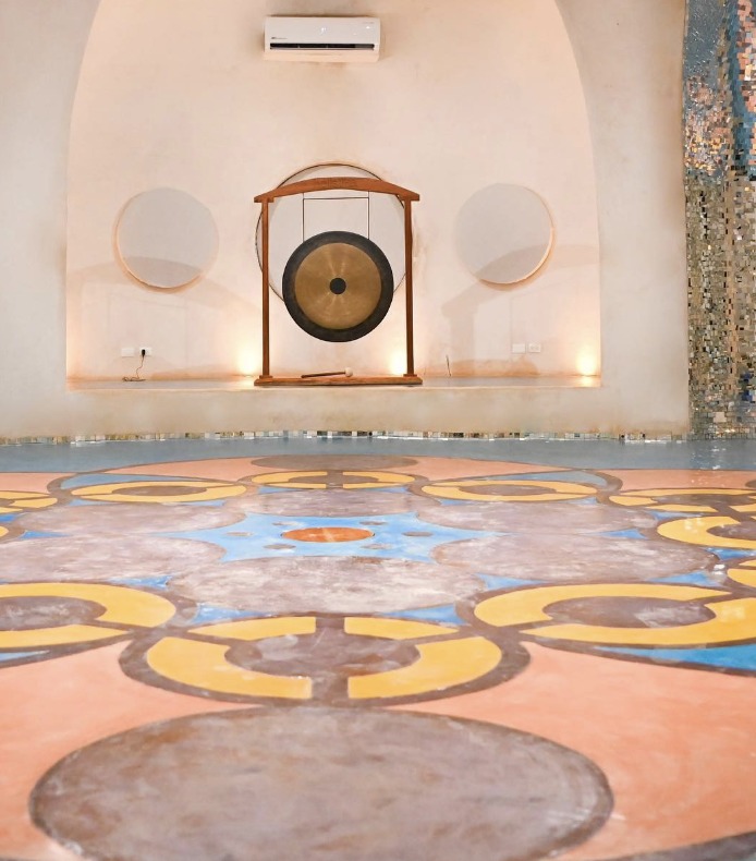 Large gong in a sound-healing studio with a painted mandala floor