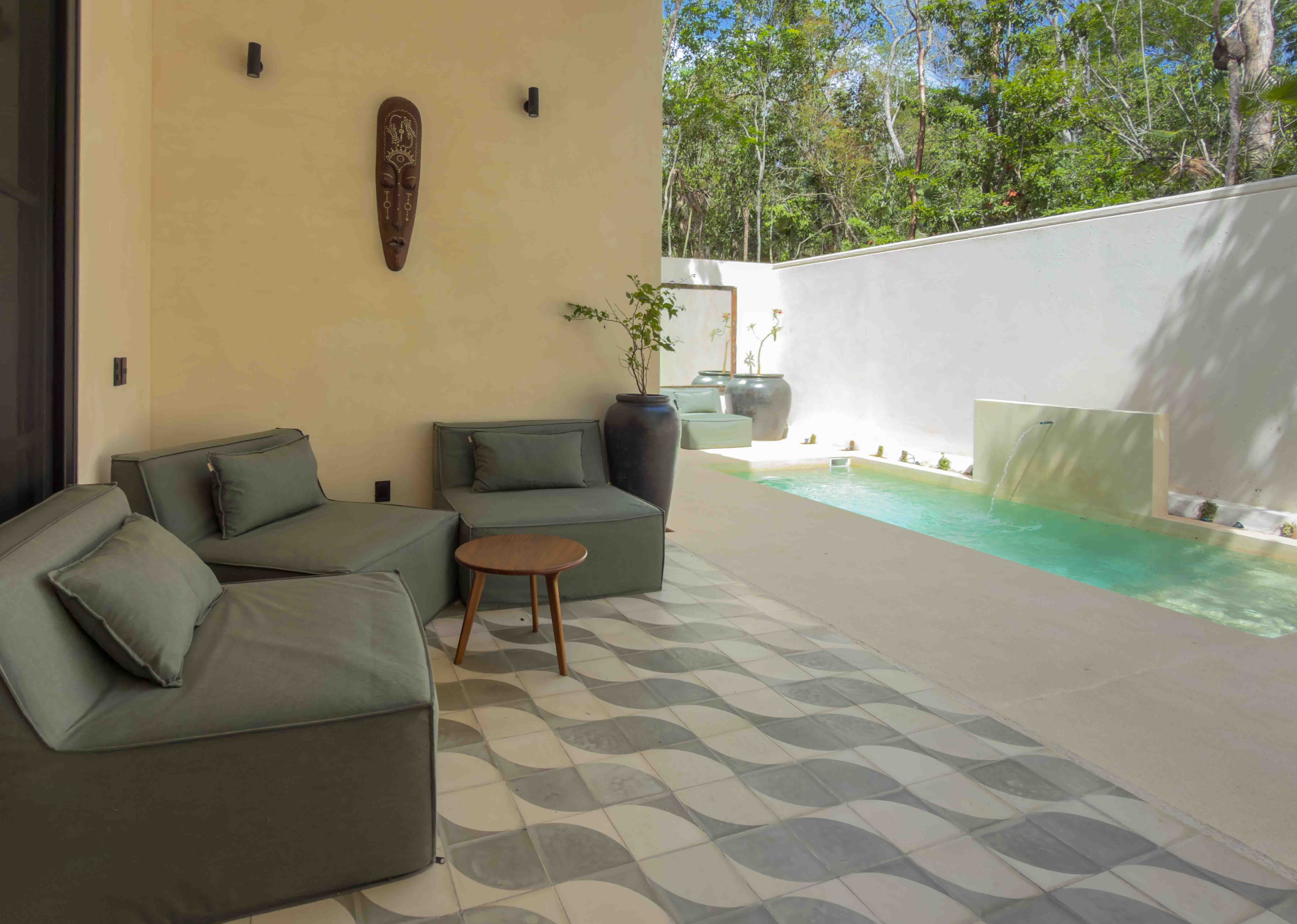 Modern terrace lounge area with geometric tiling next to a plunge pool.