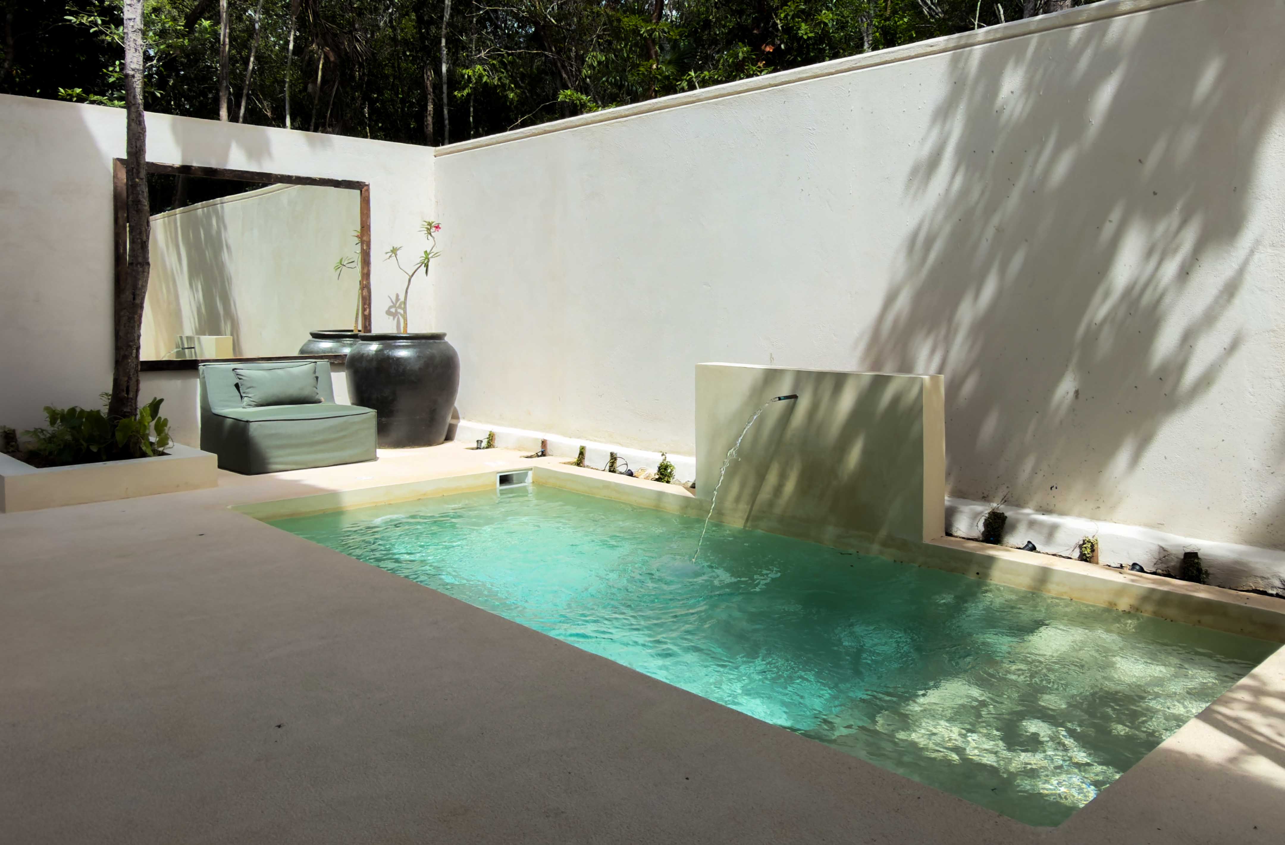 Private plunge pool with water feature and lounge seating