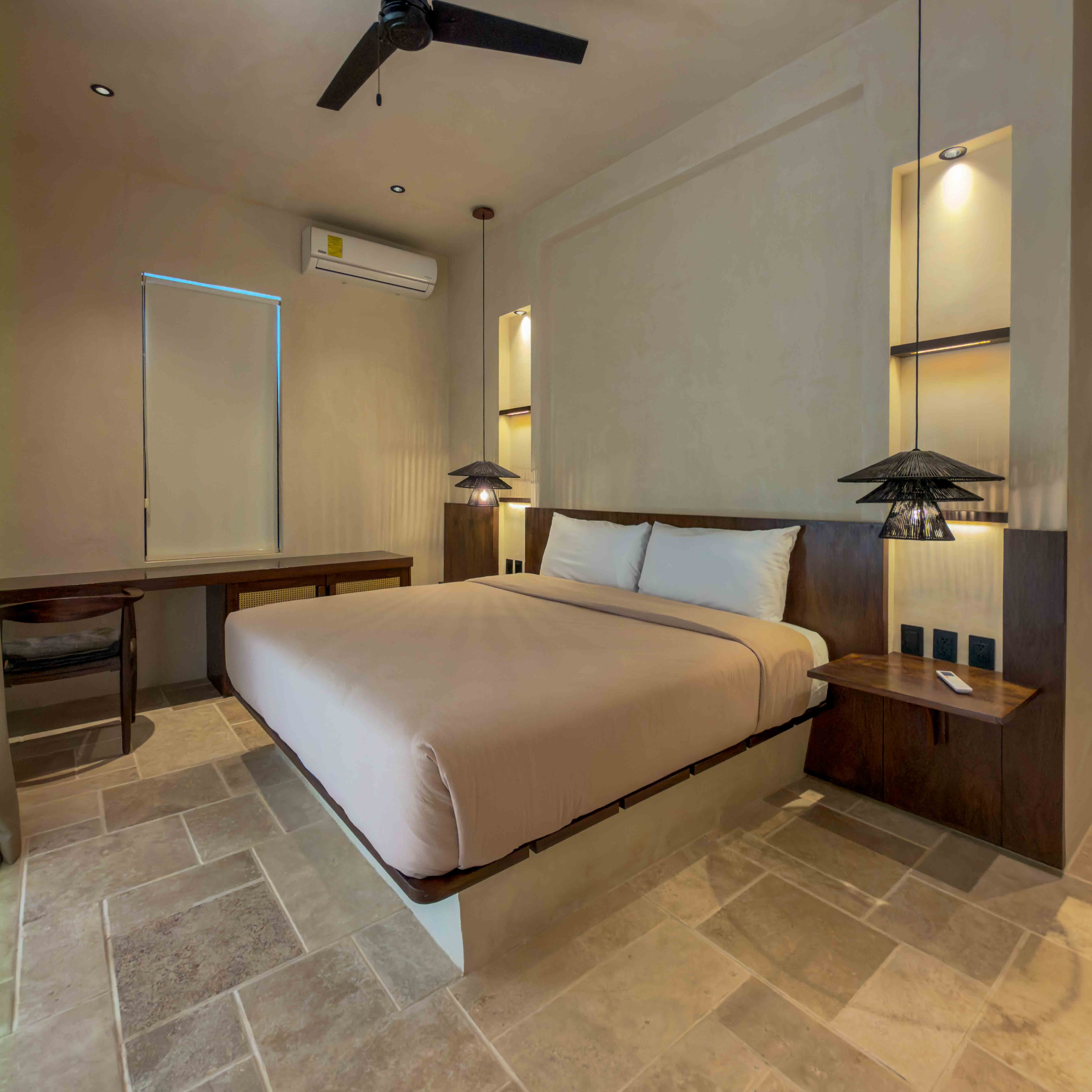 Modern minimalist suite with floating platform bed and stone flooring.
